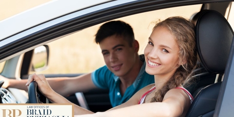 Woman and man sitting in the driver and passenger seat.