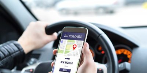 Man driving looking at a rideshare app
