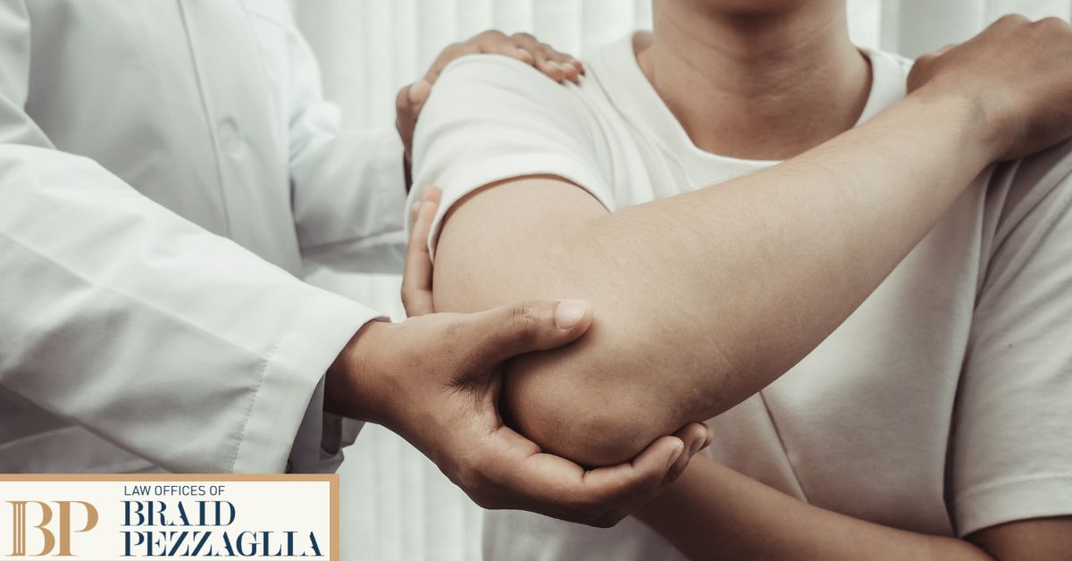 Doctor holding patient's shoulder and elbow for a stretch.