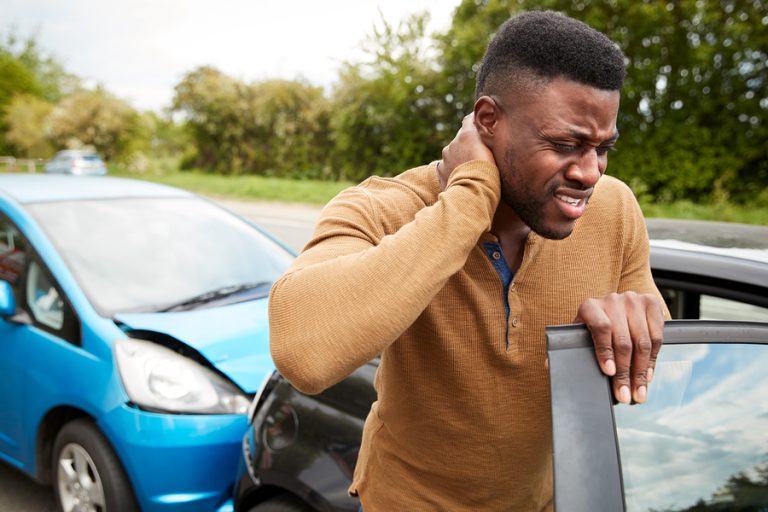 man holding his neck after a car crash